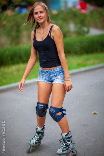 Young blonde happy girl resting in the park on a warm summer day photo
