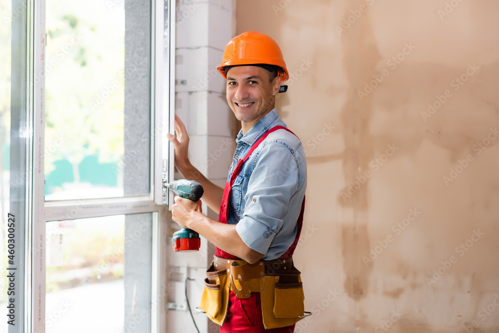 Man worker mounting window in a renovated building