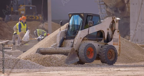 Excavation at a construction site, mini loader bobcat transports crushed stone to different construction places, where it is advisable to use compact construction equipment photo