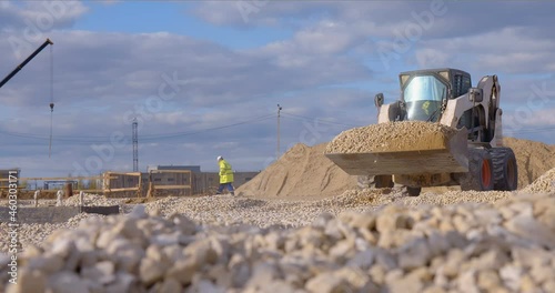 Excavation at a construction site, mini loader bobcat transports crushed stone to different construction places, where it is advisable to use compact construction equipment