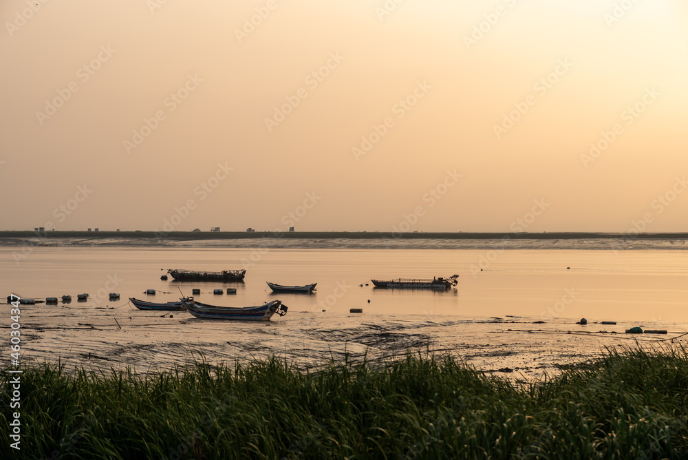 At sunrise in the morning, the sea water reflects the fishing boat At sunrise in the morning, the sea water reflects the fishing boat