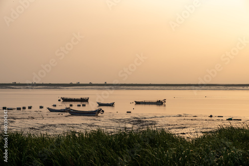 At sunrise in the morning, the sea water reflects the fishing boat © chen