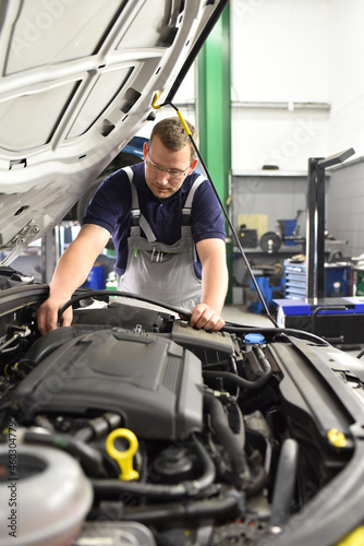 car mechanic in a workshop - engine repair and diagnosis on a vehicle