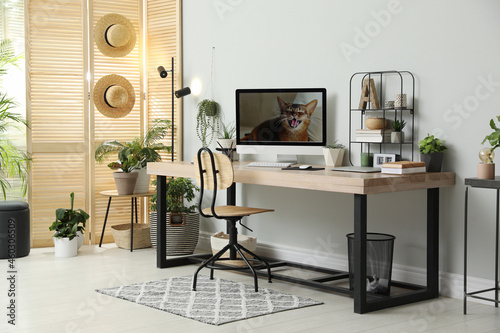 Comfortable workplace with computer in light room. Interior design