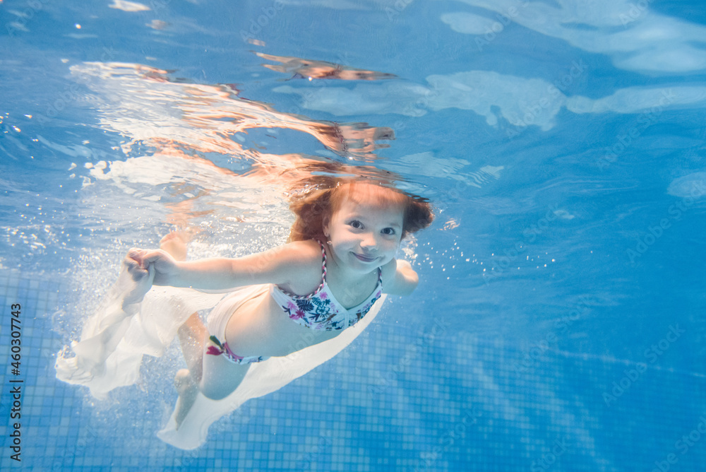 Little girl swimming under water in paddling pool. Diving. Learning ...