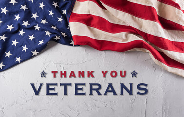 Happy Veterans Day concept. American flags against a white stone  background. November 11.