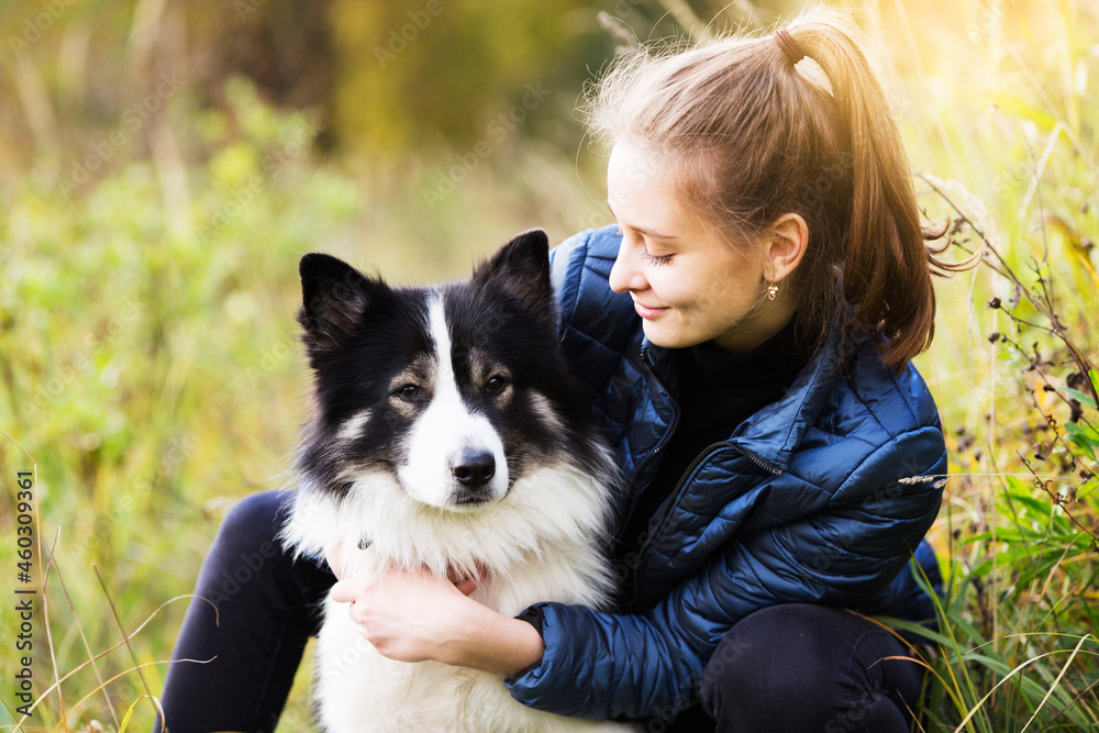 Girl in a blue jacket hugs her dog Girl in a blue jacket hugs her dog
