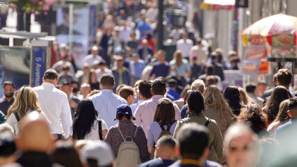 Anonymous crowd of people walking street back view