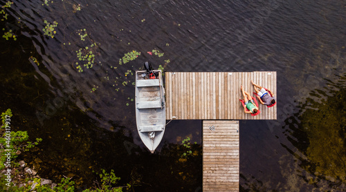 Overhead aerial image of couple sitting on a dock together. photo