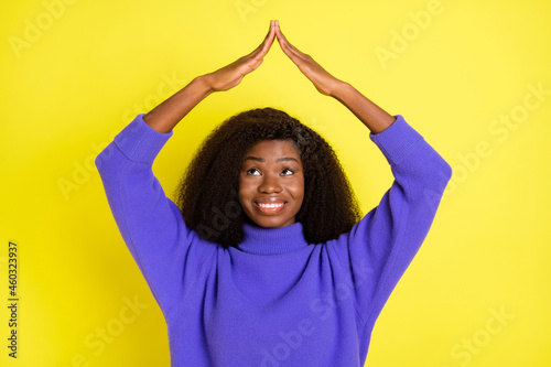Photo of adorable dark skin person look arms make house figure above head isolated on yellow color background © deagreez