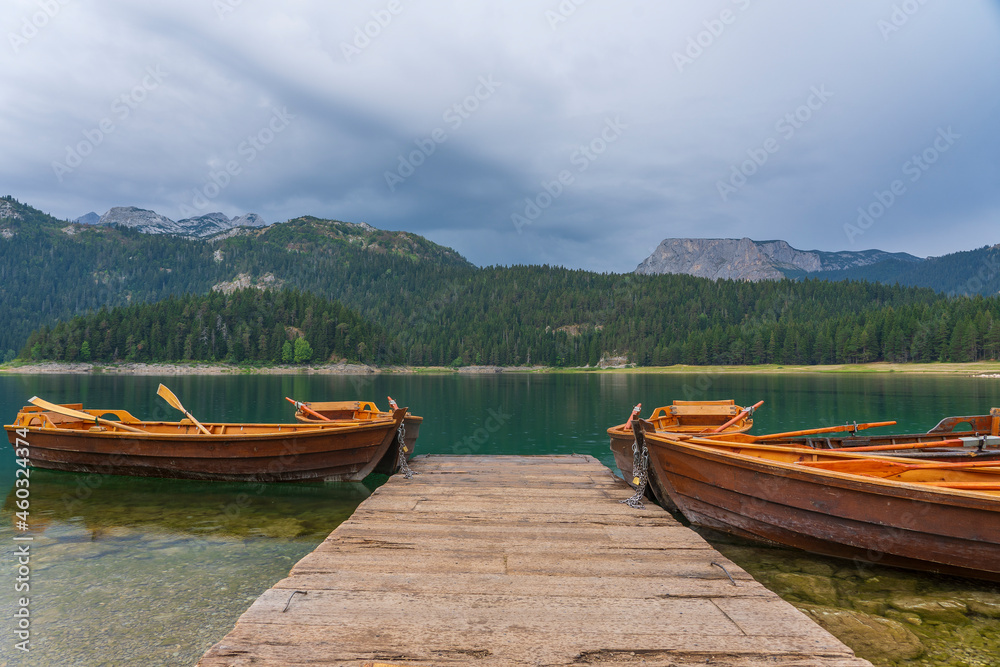 Tourist boats near wooden pier on Black lake in Montenegro, Europe