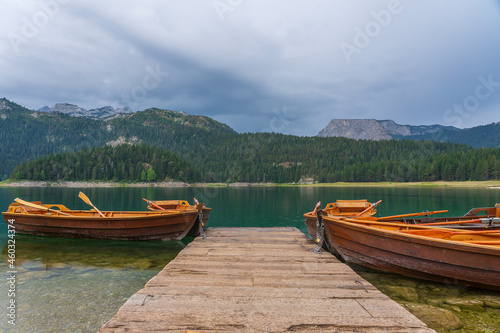 Tourist boats near wooden pier on Black lake in Montenegro, Europe © OlegD
