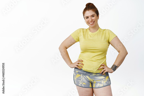Photography Portrait of young chubby woman in fitness clothing, workout in gym, smiling and