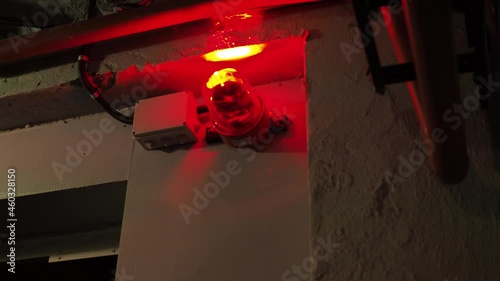alarm system in the bunker. a red burning siren on the door. red lights are spinning in the corners of the room