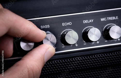 Hand adjusting volume control.Use hand to adjust the volume at the volume control button of the amplifier. photo