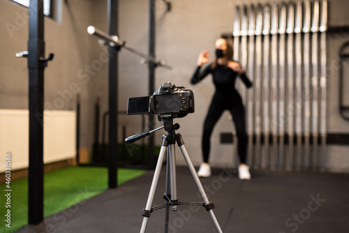 A beautiful fit woman shoots a workout on camera