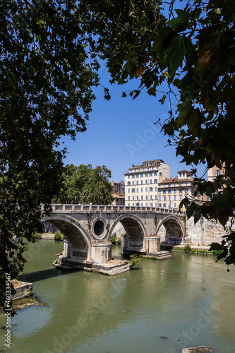 The Ponte Sistro bridge over the River Tiber flowing through Rome, Italy on a bright, summer day.