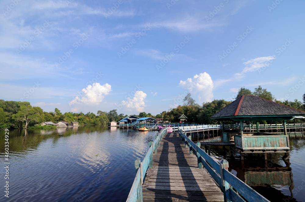 Boardwalk and wooden huts over Tahai lake in Palangka Raya, Central Borneo, Indonesia. It is one of the most popular tourist destination for local. 