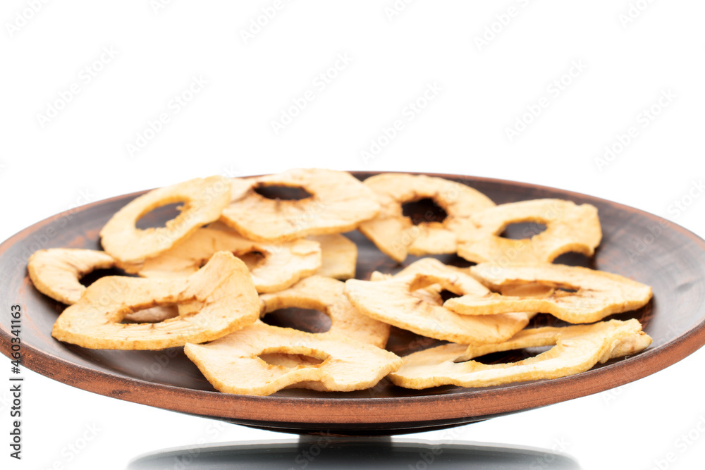 Several organic apple chips on a clay dish, close-up, isolated on white.