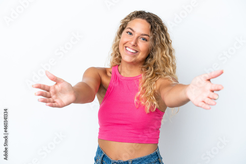 Girl with curly hair isolated on white background presenting and inviting to come with hand