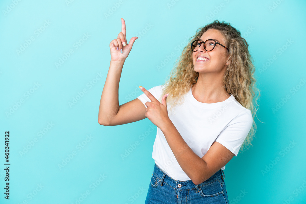 Girl with curly hair isolated on blue background pointing with the index finger a great idea Girl with curly hair isolated on blue background pointing with the index finger a great idea