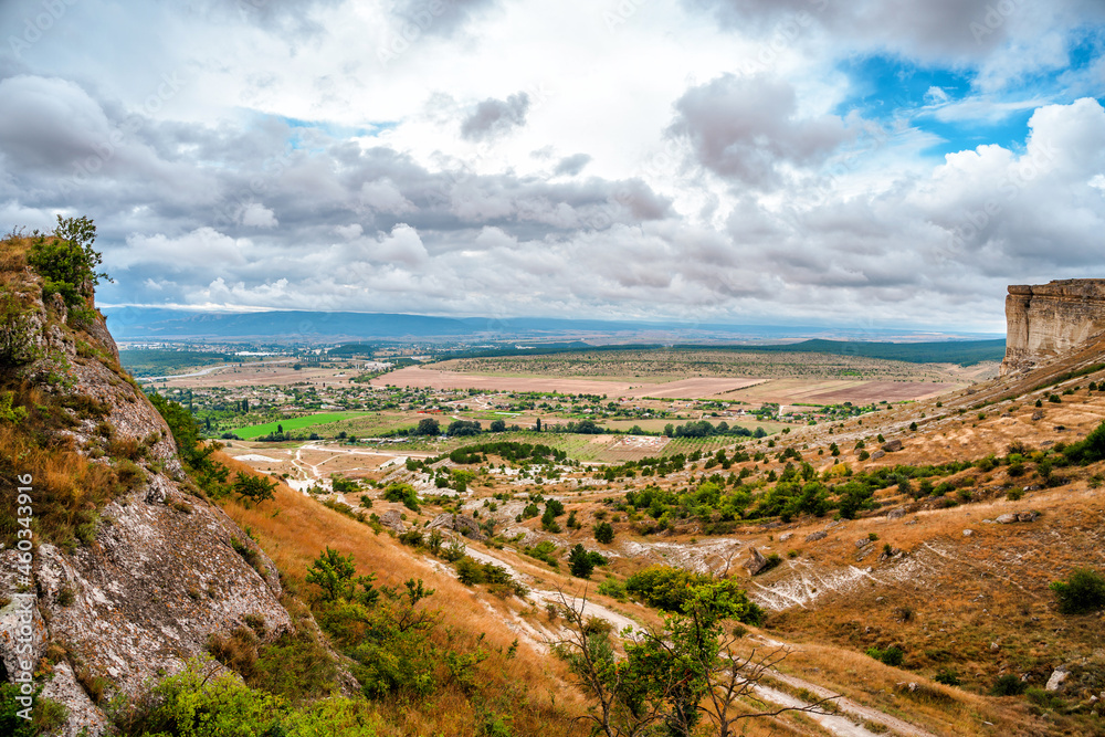 Panoramic view from the height of the White Rock in Crimea and green valley. Blue sky, a small village at the bottom Panoramic view from the height of the White Rock in Crimea and green valley. Blue sky, a small village at the bottom