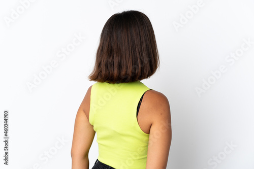 Young latin woman isolated on white background in back position and looking back