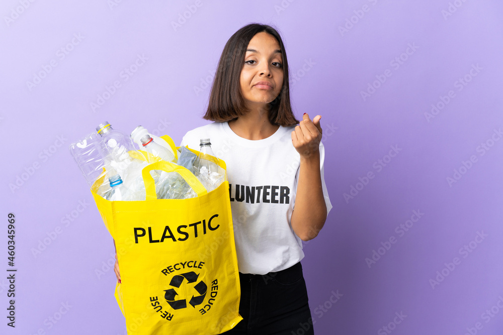 Young latin woman holding a recycling bag full of paper to recycle isolated on purple making Italian gesture Young latin woman holding a recycling bag full of paper to recycle isolated on purple making Italian gesture