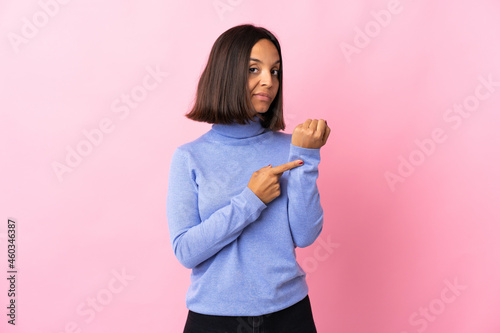 Young latin woman isolated on pink background making the gesture of being late