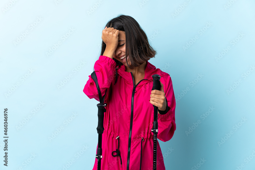 Young latin woman with backpack and trekking poles isolated on blue background has realized something and intending the solution Young latin woman with backpack and trekking poles isolated on blue background has realized something and intending the solution