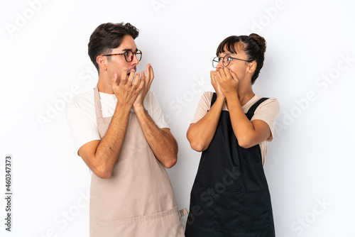 Restaurant mixed race waiters isolated on white background is a little bit nervous and scared putting hands to mouth