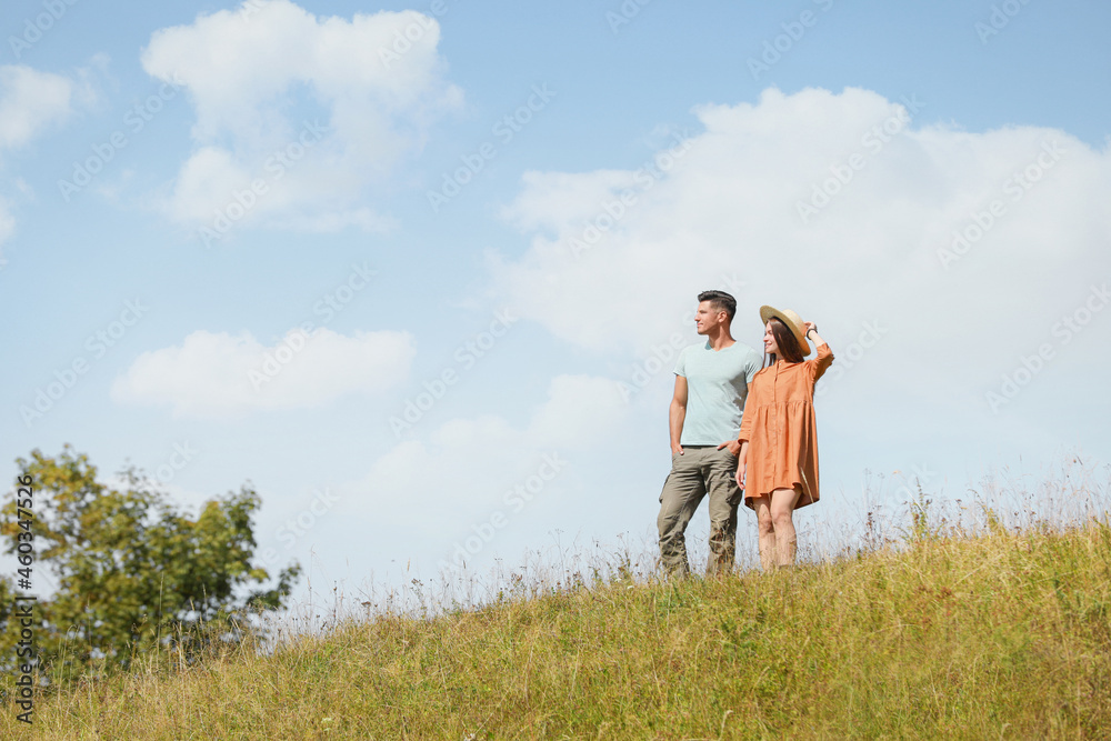 Couple spending time together on hill, space for text