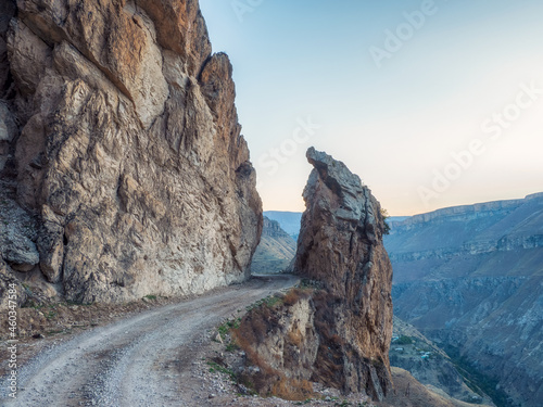 Dangerous narrow cliffside mountain road through sharp rocks.. Dangerous off road driving along mountain edge and steep cliff. Dagestan.