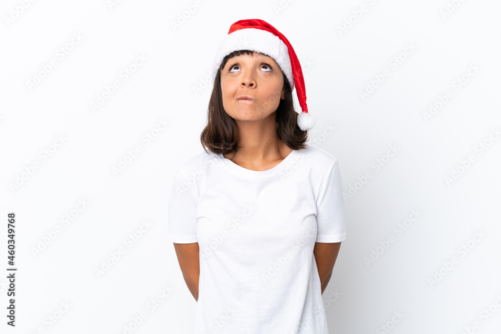 Young mixed race woman celebrating Christmas isolated on white background and looking up Young mixed race woman celebrating Christmas isolated on white background and looking up