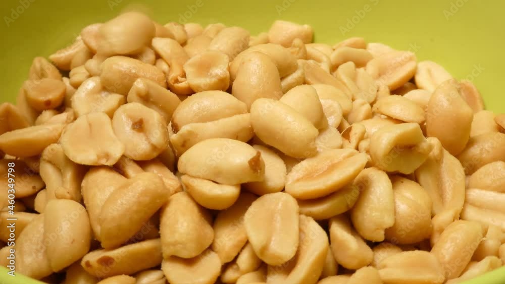 Freshly peeled roasted peanuts falling into a bowl, 360 rotation, 4k closeup Freshly peeled roasted peanuts falling into a bowl, 360 rotation, 4k closeup