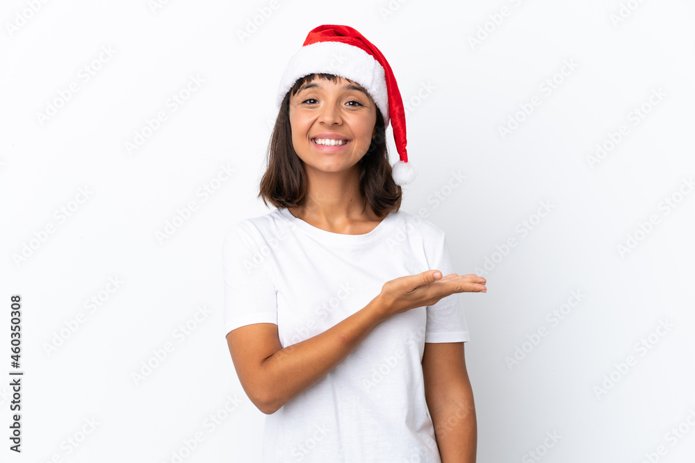 Young mixed race woman celebrating Christmas isolated on white background presenting an idea while looking smiling towards