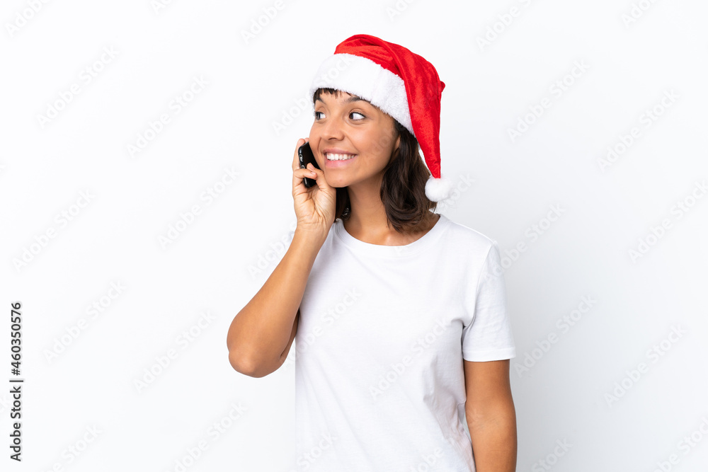 Young mixed race woman celebrating Christmas isolated on white background keeping a conversation with the mobile phone with someone Young mixed race woman celebrating Christmas isolated on white background keeping a conversation with the mobile phone with someone