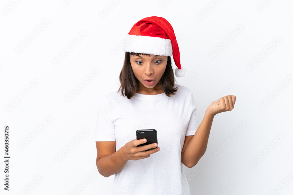 Young mixed race woman celebrating Christmas isolated on white background surprised and sending a message Young mixed race woman celebrating Christmas isolated on white background surprised and sending a message