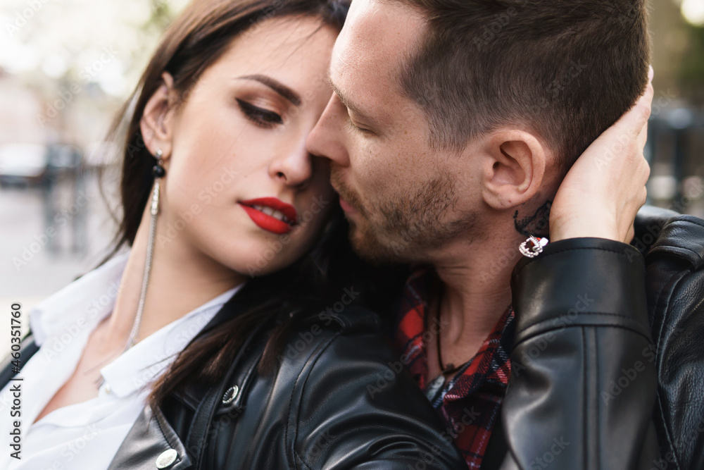 Beautiful couple in love wearing leather jackets during a date on a city street Beautiful couple in love wearing leather jackets during a date on a city street