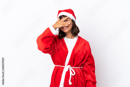 Young mixed race woman disguised as Santa Claus isolated on white background covering eyes by hands and smiling