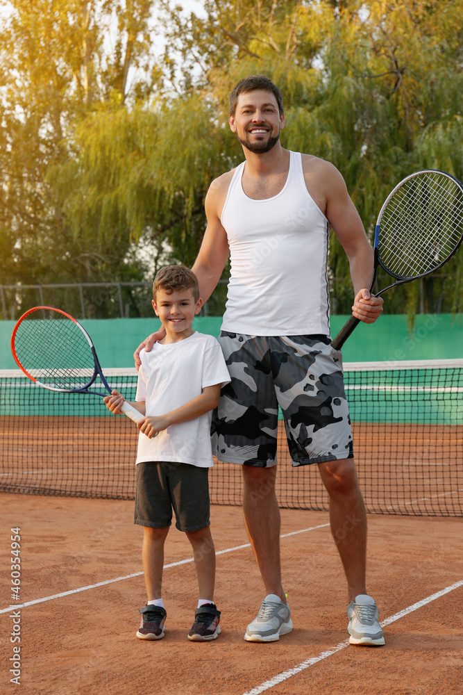 Father with his son on tennis court