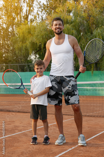 Father with his son on tennis court © New Africa