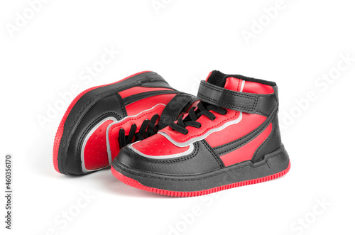 A pair of children's sports shoes on a white background. Children's shoes on a white background. Stylish red and black sneakers