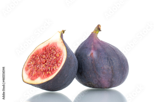 One half and one whole ripe sweet figs, close-up, isolated on white.