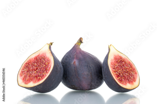 Two half and one whole ripe sweet figs, close-up, isolated on white.