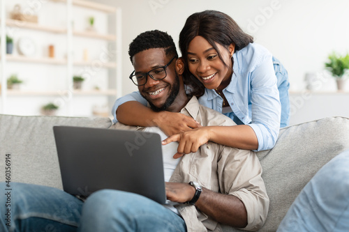 Portrait of African American couple using computer pointing at screen
