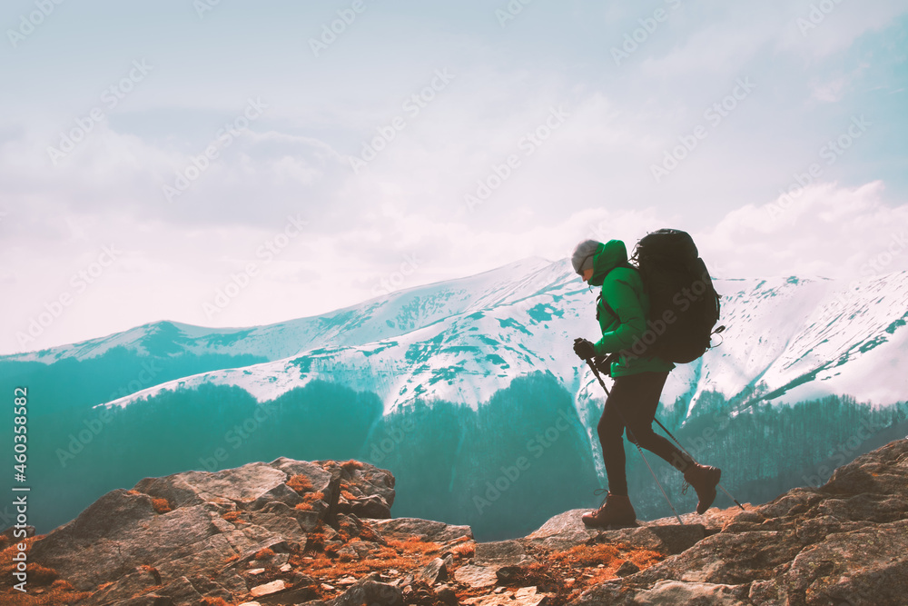 Amazing landscape with snowy mountains range and hiker with backpack on a foreground. Travel and adventure concept - obrazy, fototapety, plakaty 