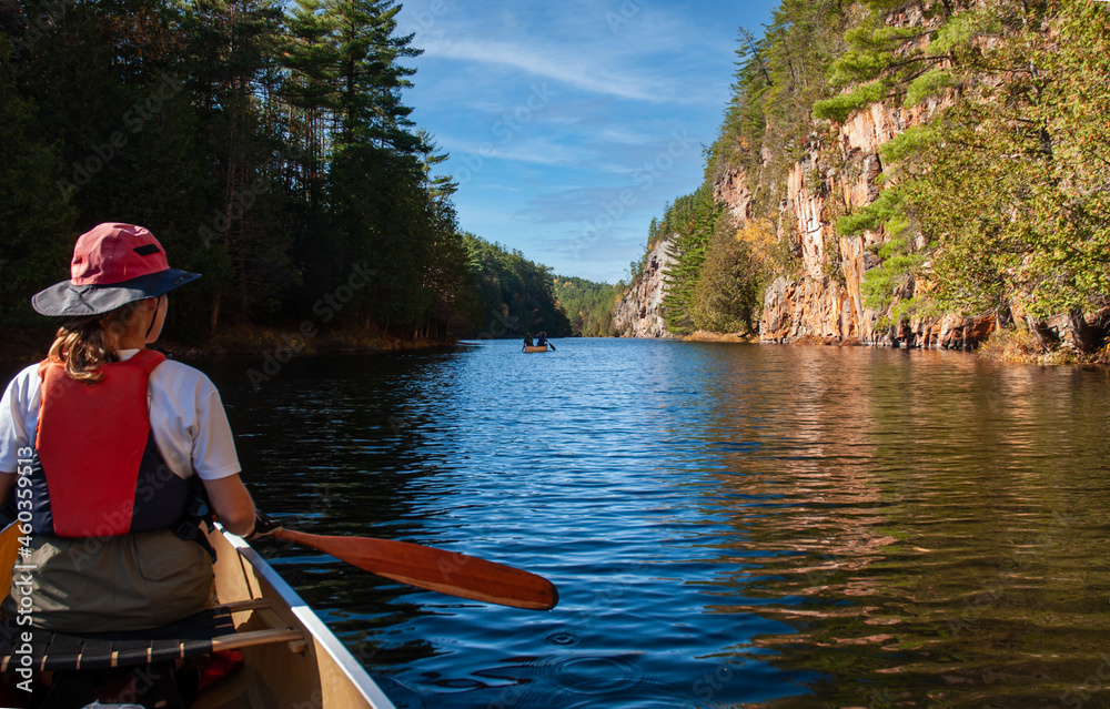 A canoe trip down the Barron River, through the Gorge  in Algonquin Park.  A female paddler looks towards another canoe and the start of the Gorge.  