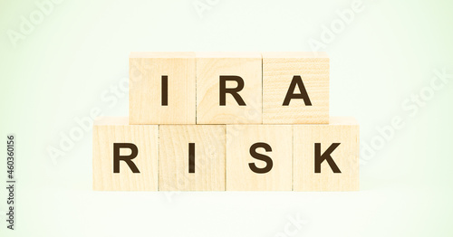 letters ira and risk with wooden cubes on light green