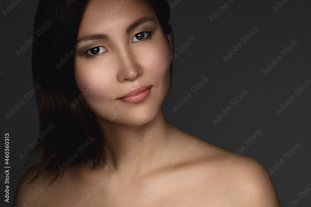 Portrait of young and beautiful asian woman on gray background